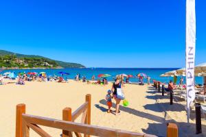 a crowd of people on a beach with umbrellas at Appartamento Arancio in Procchio