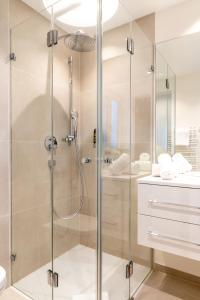 a shower with a glass door in a bathroom at Hotel Bruggwirt in Sankt Johann in Tirol