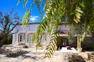 ein Gebäude mit Tischen und Stühlen davor in der Unterkunft Dimora La Cucchiara - POOL - GARDEN - PARKING in Porto Selvaggio in Santa Caterina di Nardò