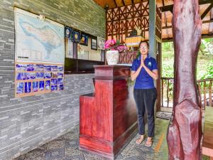 a woman standing next to a wooden podium at OYO 91228 Griya Siena in Munduk