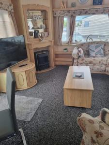 a living room with a couch and a tv at Goldensands in Foryd
