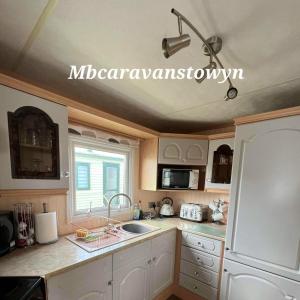 a kitchen with a sink and a microwave at Goldensands in Foryd