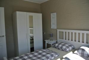 a small bedroom with a bed and a mirror at Duinnest in Noordwijkerhout