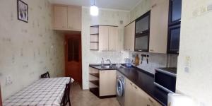 uma pequena cozinha com um lavatório e uma mesa em Двухкомнатная Арбат em Shymkent