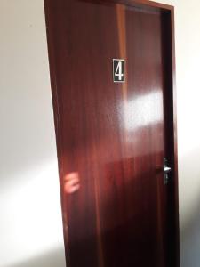 een houten deur met het nummer vier erop bij SUÍTE Nº 4 - próximo a feira da sulanca caruaru-PE in Caruaru
