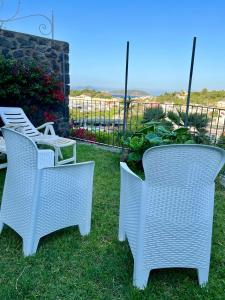 two white wicker chairs sitting on the lawn at Casa con vista a Ischia in Ischia
