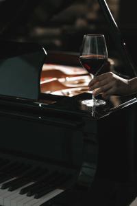 osoba trzymająca kieliszek wina na pianinie w obiekcie Slemani Rotana w mieście As-Sulajmanijja