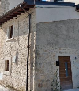een stenen gebouw met een deur aan de zijkant bij Casetta Tipica in Borgo, indipendente, ristrutturata in LʼAquila