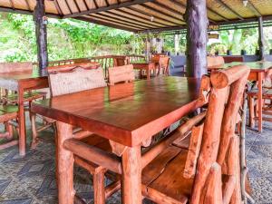 uma mesa de madeira e cadeiras num restaurante em OYO 91228 Griya Siena em Munduk