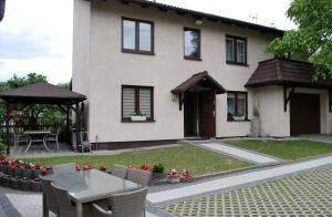 a house with a table and chairs in front of it at Pokoje Gościnne Beata in Wisełka