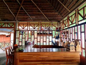 a room with a bar in a building with windows at Milía Amazon Lodge in Iquitos