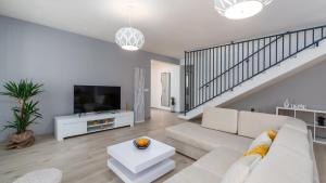 een witte woonkamer met een bank en een tv bij Villa Oliveti by Villas Holiday in Frata