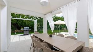 een eetkamer met een tafel en stoelen en een zwembad bij Villa Oliveti by Villas Holiday in Frata