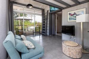 Una sala de estar con un sofá azul y un televisor. en Bousquet Villa Vue Exceptionnelle, en Moliets-et-Maa