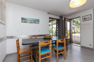Un comedor con una mesa y sillas negras. en Bousquet Villa Vue Exceptionnelle, en Moliets-et-Maa