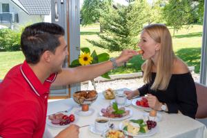 Een man en een vrouw die aan een tafel eten. bij Wellnesshotel Sonnenhof & Sonnhalde in Ühlingen-Birkendorf