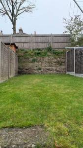 a fence in a yard with a grassy field at Stunning 1-Bed Apartment in London in London