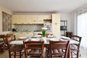 cocina y comedor con mesa y sillas en Casamare a 2 passi dalla spiaggia en Tortolì