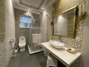 y baño con lavabo, aseo y espejo. en Arish Luxury Suites en Skardu