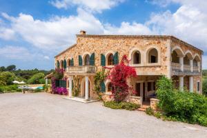 ein großes Steingebäude mit Blumen darauf in der Unterkunft Luxusfinca Son Mas in Felanitx