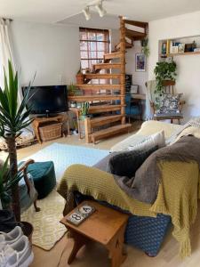 ein Wohnzimmer mit einem Sofa und einer Treppe in der Unterkunft Charming Cottage, Central Taunton. in Taunton