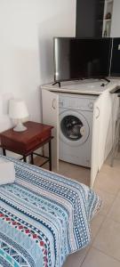 een kamer met een wasmachine en een tv bij Quiet studio near to the airport 1 in Heraklion