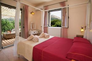 a bedroom with a large bed with a large window at Stamoulis Villas in Ayia Evfimia