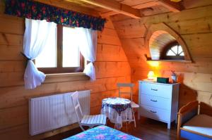 una camera da letto in una baita di legno con un letto e una cassettiera di Góralska Ostoja a Pcim