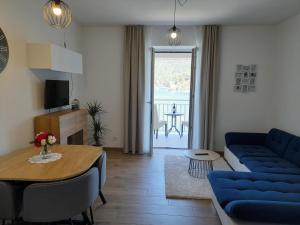ein Wohnzimmer mit einem blauen Sofa und einem Tisch in der Unterkunft Apartments Palma in Polače