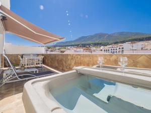 a swimming pool on the roof of a building with wine glasses at Cubo's Apartamento Boutique Alhaurin in Alhaurín el Grande
