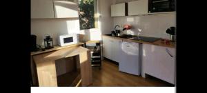a kitchen with white cabinets and a microwave at Jolies Appartement 6 couchages a praloup 1600 avec balcons in Uvernet
