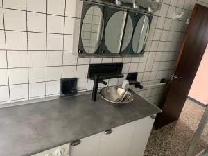 a kitchen with a counter with four mirrors on the wall at Apt Sueiras in Burela de Cabo +15 photos