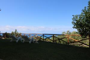 zwei Stühle auf dem Gras neben einem Zaun in der Unterkunft Antico Portale in Ascea