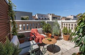 un pequeño balcón con una mesa y macetas en Hotel Casa Sagnier, en Barcelona