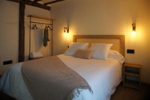 a bedroom with a large white bed with two pillows at Fábrica de Harinas La Gloria in San Millán de la Cogolla