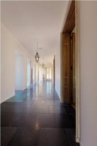 pusty korytarz domu z podłogą wyłożoną kafelkami w obiekcie B&B Domaine Villa Bayard w mieście Kanne