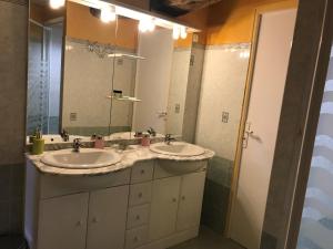 a bathroom with two sinks and a large mirror at Le Mas Bertrand in Villefranche-de-Panat