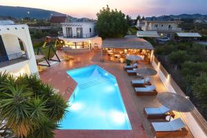an overhead view of a swimming pool with chairs and umbrellas at Christina Dream Village in Pastida