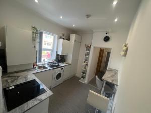 a kitchen with a sink and a washing machine at Zams rooms in Stoke on Trent
