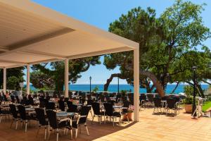 eine Gruppe von Tischen und Stühlen unter einem Pavillon in der Unterkunft htop Caleta Palace #htopBliss in Platja  d'Aro