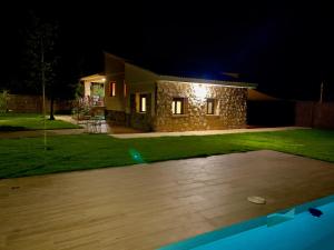 a stone house at night with a yard at La Casa OM in Almorox