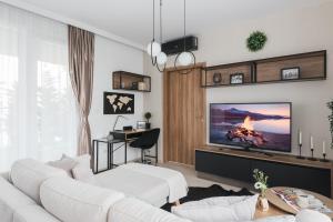 een woonkamer met witte meubels en een flatscreen-tv bij Downtown Penthouse Budapest in Boedapest