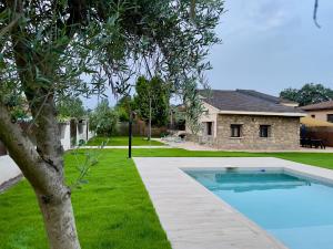 a swimming pool in a yard next to a house at La Casa OM in Almorox
