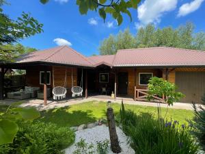 a log cabin with a patio and a yard at Zarzecze 27A in Augustów