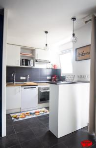 a kitchen with white cabinets and a counter top at MADININA DAY in Saint-Médard-en-Jalles