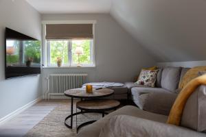 ein Wohnzimmer mit einem Sofa und einem Tisch in der Unterkunft Villa Granliden in Ludvigsborg