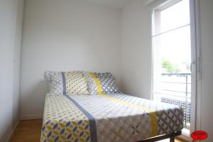 uma pequena cama num quarto com uma janela em MADININA DAY em Saint-Médard-en-Jalles