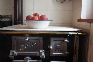 un tazón de manzanas sentado en la parte superior de un horno en Dalla Dora- A peaceful place in the Dolomites, en Villa
