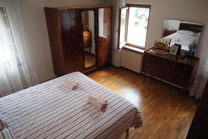 1 dormitorio con cama, tocador y espejo en Dalla Dora- A peaceful place in the Dolomites, en Villa