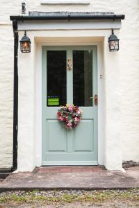 a blue door with a flower basket on it at The Green Door Vegan B&B in Llanon